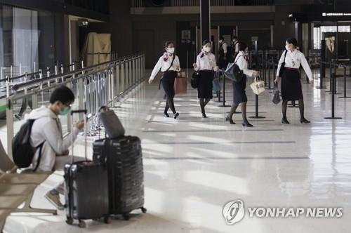 (도쿄 AP=연합뉴스) 일본에서 신종 코로나바이러스 감염증(코로나19)이 빠르게 확산하는 가운데 지난달 19일 수도권 관문인 나리타(成田)공항에서 항공업 종사자들이 마스크를 쓰고 이동하고 있다.