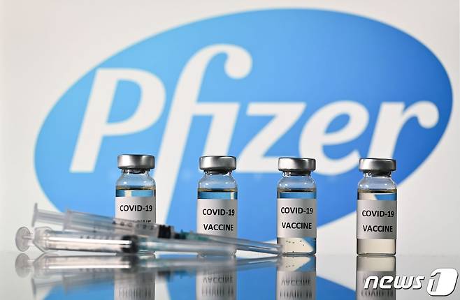 코로나19 백신 스티커가 부착된 병과 미국 제약회사 화이자 로고가 부착된 주사기. © AFP=뉴스1