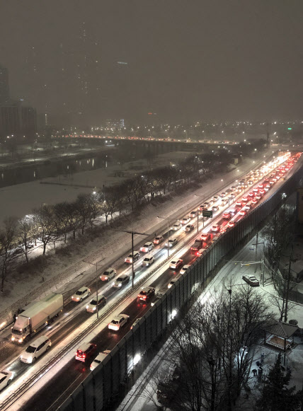 눈이 내린 6일 밤 서울 서부간선도로에서 퇴근길 차량이 내린 눈에 서행하며 긴 꼬리를 물고 있다 (사진=연합뉴스)