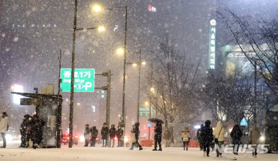 연일 한파가 이어지며 눈이 내리고 있는 6일 오후 서울 종로구 광화문네거리에서 시민들이 발걸음을 옮기고 있다. 뉴시스