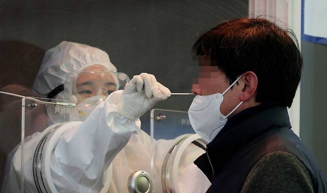 A medical worker takes a sample at a temporary screening center in front of Seoul Station. (Kim Hye-yun, staff photographer)
