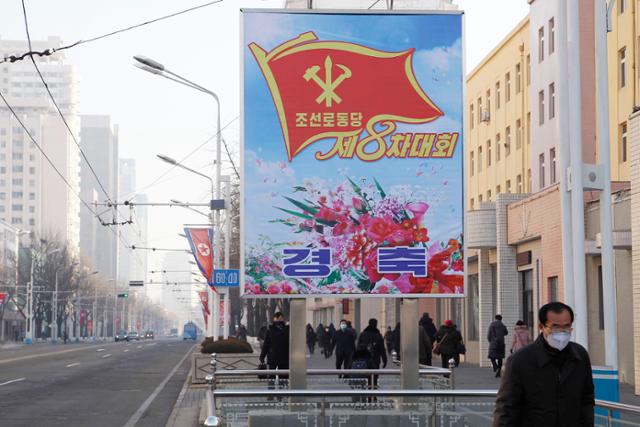 6일 북한 평양에서 주민들이 평양 중앙지구를 따라 설치된 조선노동당 제8차 대회를 알리는 선전물 앞을 지나고 있다. 평양=AP 뉴시스