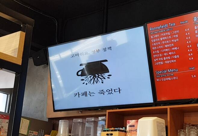 서울시 관악구 한 카페의 디지털 메뉴판에 “커피는 죽었다”라는 문구가 적힌 사진이 게시 돼있다. /사진=김나현 기자.
