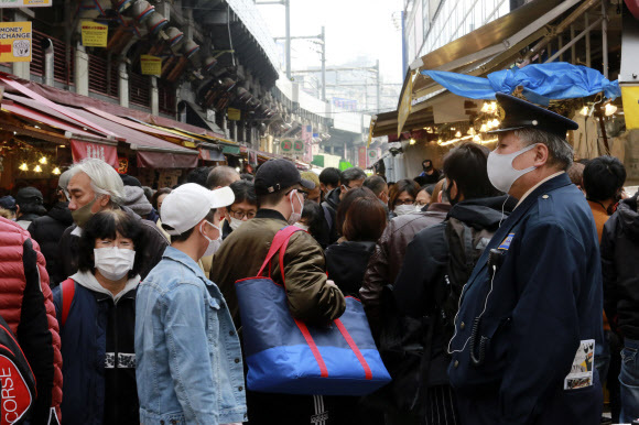지난달 30일 일본 도쿄 우에노에 있는 아메요코 전통시장이 마스크를 착용한 채 새해맞이 쇼핑에 나선 시민들로 북적이고 있다. AP/연합뉴스