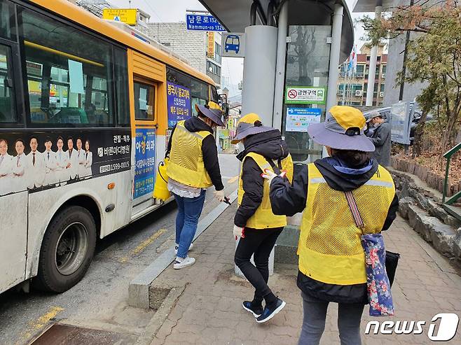 버스정류장에서 코로나19 방역 활동을 하고 있는 성남시민순찰대 모습.(성남시 제공) © News1