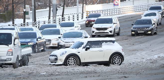 밤사이 많은 눈이 내린 7일 오전 아직 제설 작업이 완료되지 않은 서울 강남구 영동대로에서 한 차량이 눈에 갇혀 움직이지 못하고 있다. 연합뉴스