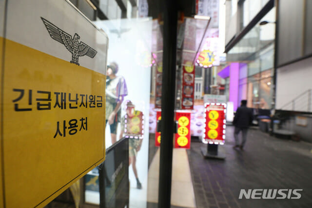 정부가 코로나19 확산에 대응한 맞춤형 피해지원 대책을 발표한 지난해 12월 29일 서울 중구 명동의 한 상점에 긴급재난지원금 사용 가능 안내문이 붙어있다. (사진=뉴시스)