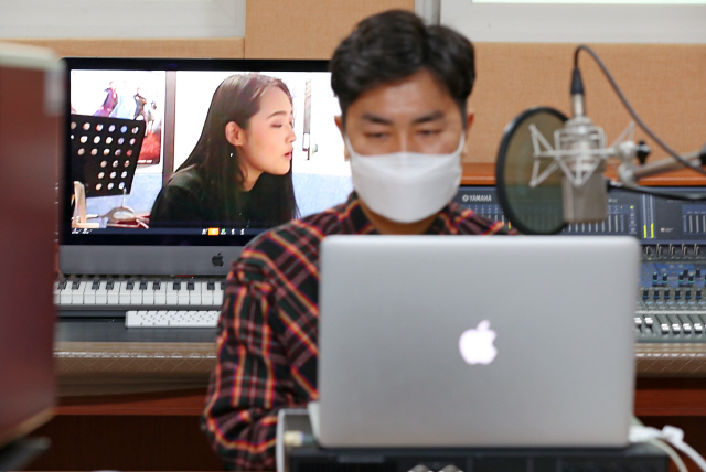 지난해 4월 14일 대구 남구 경북예술고등학교에서 실시된 온라인 실용 음악 실기 수업에서 모니터 노래를 부르는 학생의 모습이 모니터 위에 띄워져 있다. /대구=연합뉴스