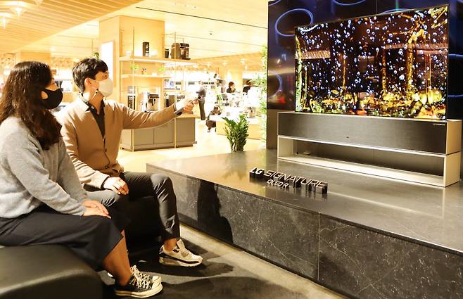 롯데백화점 본점 8층 팝업매장에서 고객들이 LG시그니처 올레드 R을 시연해보고 있다.