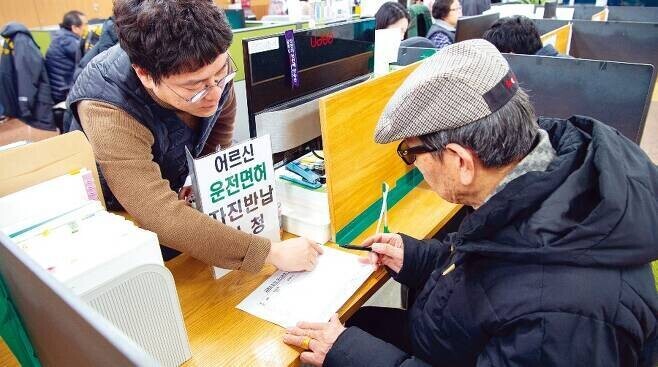 서울시의 한 주민센터에서 한 고령자가 운전면허증 자진 반납 신청서를 쓰고 있다. <한겨레> 자료사진