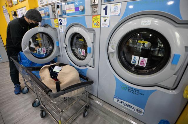10일 서울 송파구의 24시간 셀프빨래방에서 한 시민이 빨래감을 세탁기에 넣고 있다. 영하 20도에 가까운 한파가 이어지자 세탁기 배수관 동파 등의 피해를 우려한 시민들이 빨래방을 찾고 있다. 뉴스1