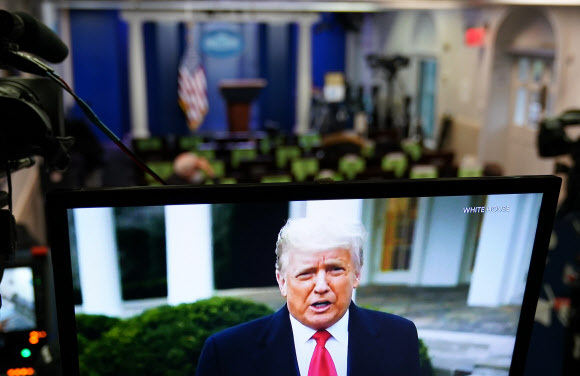 지난 6일(현지시간) 도널드 트럼프 미국 대통령이 연방 의회에 난입한 시위대를 향해 트위터에 올린 영상 메시지가 백악관 브리핑룸의 TV를 통해 방영되고 있다. 워싱턴 AFP=연합뉴스