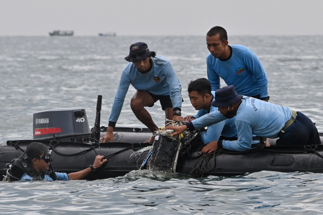 인도네시아 해군 잠수사들이 10일(현 지시간) 스리위자야항공 SJ182편 보잉 737-500 여객기가 추락한 란짱섬 인근 해역에서 잔해를 인양하고 있다. /AFP연합뉴스