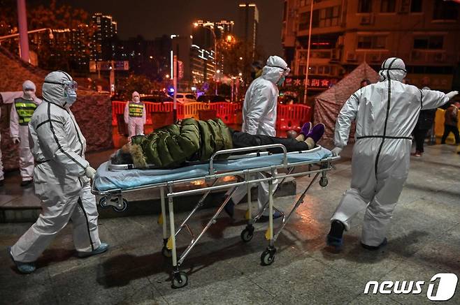 작년 1월25일 중국 후베이성 우한시에서 의료진들이 코로나19 감염자로 추정되는 환자를 이송하고 있다. © AFP=뉴스1