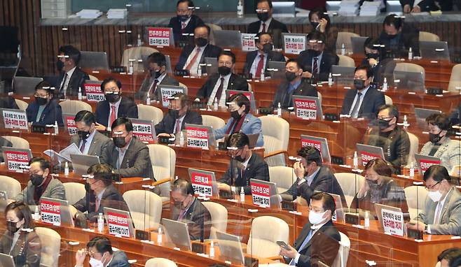 국민의 힘 의원들이 지난해 12월 9일 오후 좌석 앞에 '공수처법 저지' 등의 피켓을 붙이고 본회의에 참석하고 있다. /연합뉴스