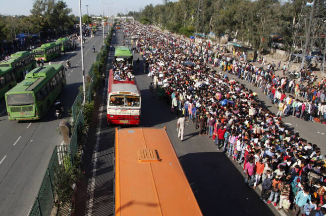인도 이주 노동자들이 지난 3월28일 뉴델리에서 고향으로 가기 위해 정부가 제공하는 버스를 기다리고 있다. AP연합뉴스