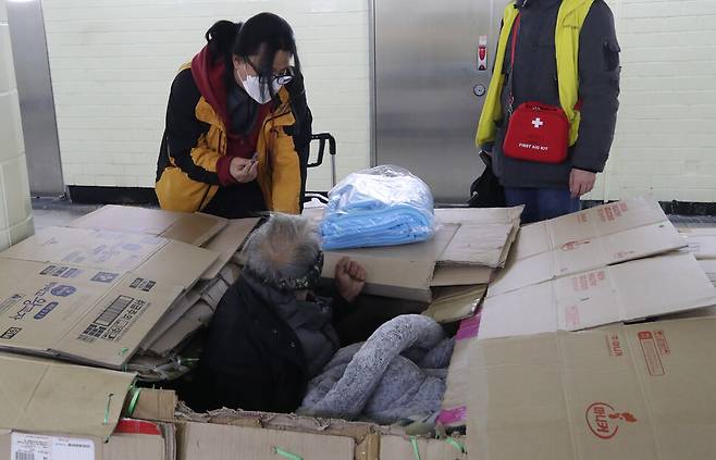 강력한 한파가 연일 계속된 10일 밤 서울역 인근 지하도에서 서울시립 다시서기종합지원센터 노숙인 아웃리치 상담이 한 노숙인에게 담요와 감기약을 전달하고 있다. 백소아 기자 thanks@hani.co.kr