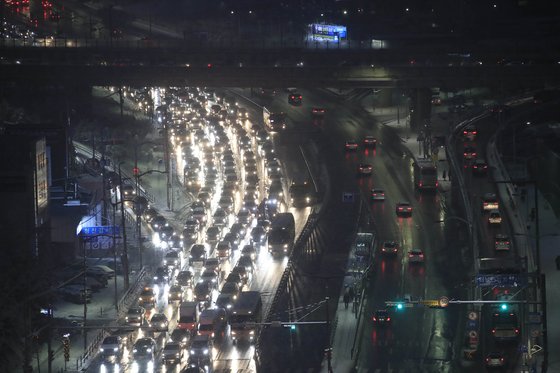 서울 지역에 눈이 내리고 있는 12일 오후 서울 동작구 사당역 인근 도로에서 차량들이 서행하고 있다. 뉴시스