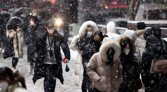 눈 내리는 퇴근길 - 눈이 내린 12일 저녁 서울 강남역 인근에서 시민들이 퇴근길을 재촉하고 있다. 2021.1.12 연합뉴스