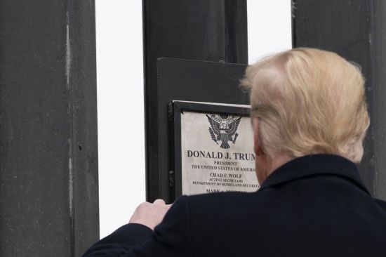 도널드 트럼프 미국 대통령이 12일 국경장벽에 붙어 있는 자신의 이름이 적힌 명판을 바라보고 있다. [이미지출처=AP연합뉴스]