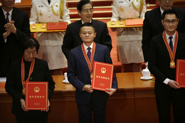 마윈(가운데) 알리바바 창업자가 지난 2018년 12월12일 베이징 인민대회당에서 진행된 ‘중국 개혁개방 40주년 경축식’에서 유공자로 상을 받고 있다. 그의 오른쪽에 마화텅 텐센트 회장도 보인다. /AP연합뉴스