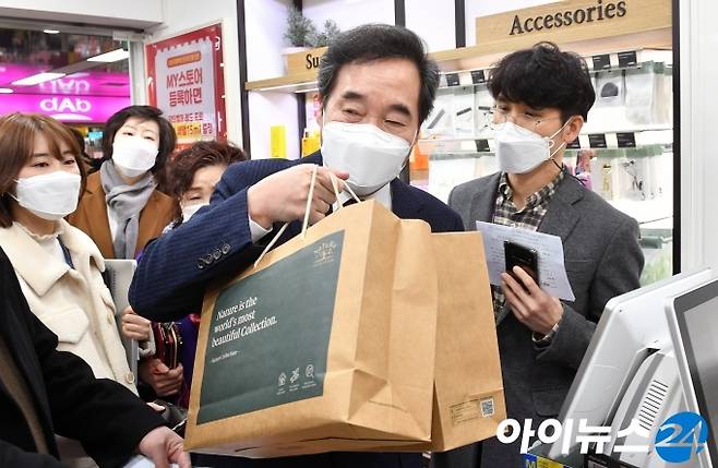 이낙연 더불어민주당 대표가 14일 코로나 이익공유제 실현 현장 방문의 일환으로 서울 영등포 지하상가 내 네이처컬렉션을 찾아 온라인몰에서 사전 구매한 상품을 수령하고 있다.