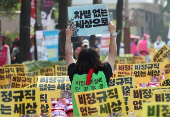 People working as nonregular employees at schools stage a rally in demand of converting job status as regular employees in Incheon in July 2019. (Yonhap)