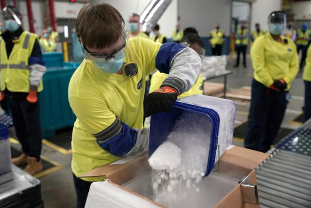 지난해 12월 13일 미국 미시간주 포티지의 화이자 공장에서 직원들이 코로나19 백신 운송 상자에 드라이아이스를 채워 넣고 있다. 포티지 AP=연합뉴스