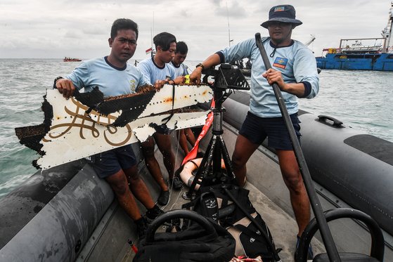 인도네시아 해군 대원들이  15 일 ( 현지시간 ) 자카르타 앞 바다로 추락한 스리위자야 항공  SJ 182 편 여객기로 추정되는 동체 잔해를 수거해 이동하고 있다 . [로이터= 연합뉴스]