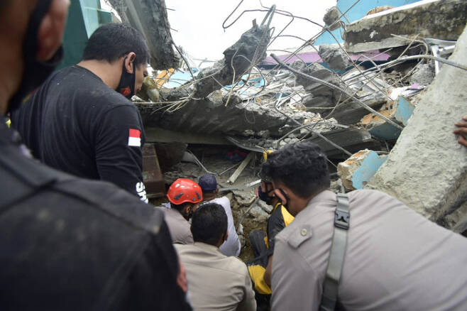 15일 규모 6.5의 강진이 발생한 인도네시아 술라웨시섬 마무주에서 구조대원들이 무너진 건물 잔해 속에서 생존자를 찾고 있다. AP연합뉴스