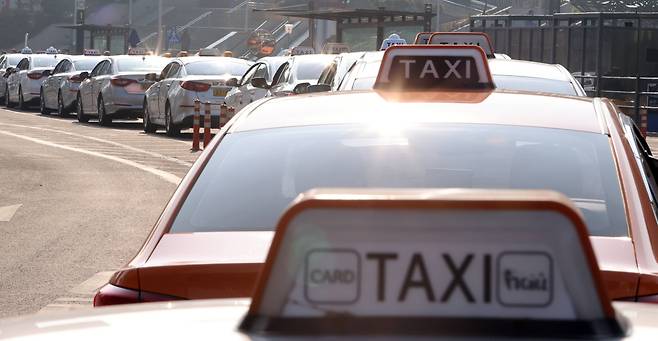Taxis wait for passengers in front of Seoul Station on Dec. 28, 2020. (Yonhap)