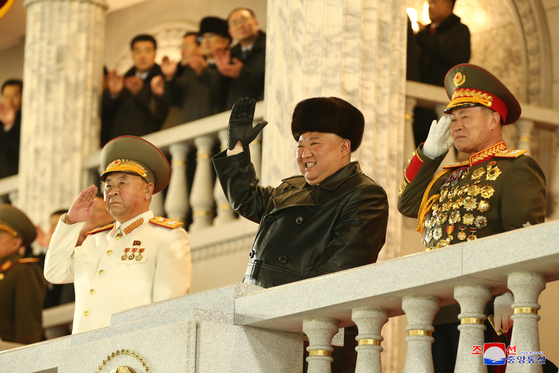 North Korean leader Kim Jong-un waves at troops marching at the military parade in Pyongyang on Thursday night, according to this state media photograph. [YONHAP]