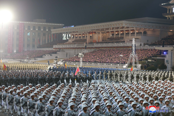 Thousands of North Korean soldiers march in unison at a military parade in Pyongyang on Thursday night, according to this state media photograph. [YONHAP]