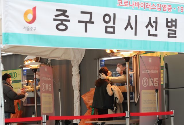 국민의당 안철수 대표가 15일 서울광장에 마련된 임시 선별검사소에서 의료 자원봉사에 나서 검체를 채취하고 있다. 연합뉴스