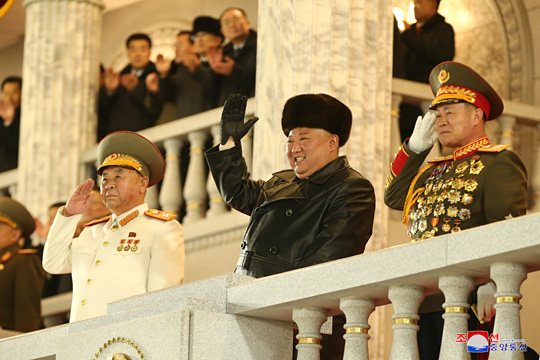 14일 열병식에서 김정은(왼쪽) 북한 국무위원장이 손을 들어 경례를 받고 있다. 오른쪽은 박정천 인민군총참모장.  연합뉴스