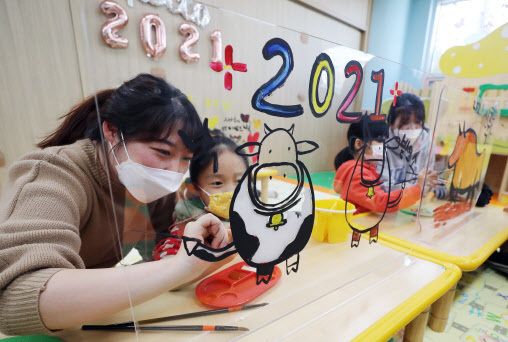지난 6일 광주 북구청직장어린이집에서 신축년 새해를 맞아 어린이들이 선생님들과 함께 투명 아크릴판에 소를 그리고 색칠하는 놀이를 하고 있다. (사진=연합뉴스)