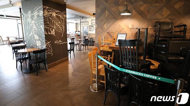스타벅스가 사회적 거리 두기 2단계 격상에 맞춰 서울과 경기 모든 매장의 좌석을 30% 이상 축소하는 등 방역 수칙을 강화했다. 18일 오후 서울의 한 스타벅스 매장 한켠에 의자와 테이블이 쌓여있다. 2020.8.18/뉴스1 © News1 박지혜 기자