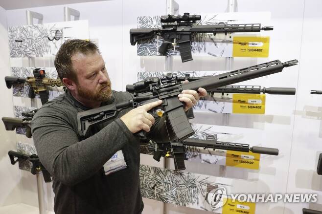 2019년 NRA 연례총회에 전시된 AR-15 소총을 만져보는 참석자 [AP=연합뉴스 자료사진]