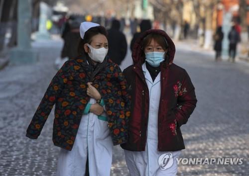 중국 헤이룽장성 하얼빈에서 마스크를 쓴채 거리를 걷는 의료진 [EPA=연합뉴스]