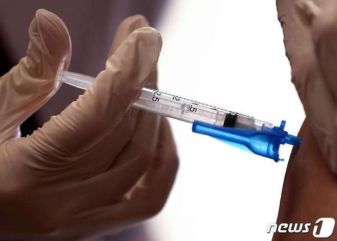 지난 7일(현지시간) 미국 캘리포니아주 로스앤젤레스 미션힐스에 있는 한 의료시설에서 의료진이 우선접종 대상자에게 모더나 코로나19 백신을 투여하고 있다. © AFP=뉴스1