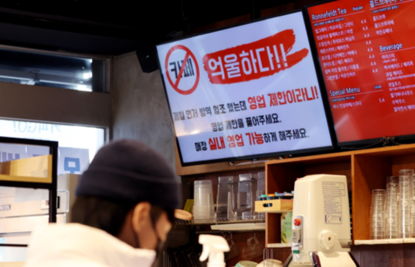 카페는 식당과 마찬가지로 오는 18일부터 오후 9시까지 매장 내 취식이 허용된다. 사진은 매장 취식을 금지한 거리두기 조치에 반발해 항의문구를 게시한 서울 관악구의 한 커피숍/연합뉴스