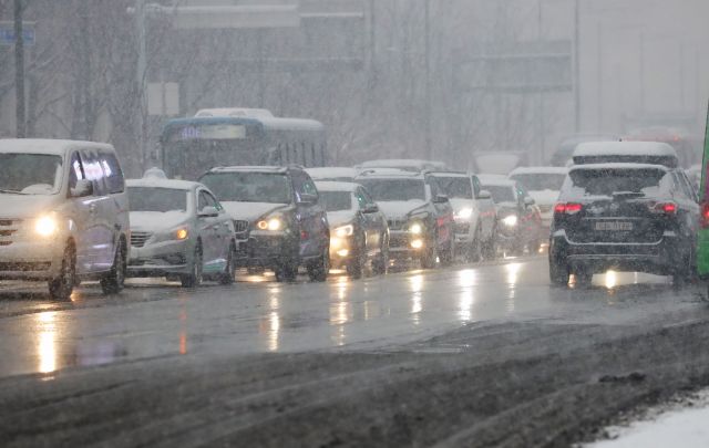 많은 눈이 내린 지난 12일 오후 서울 세종대로에서 차들이 서행하고 있다. 연합뉴스