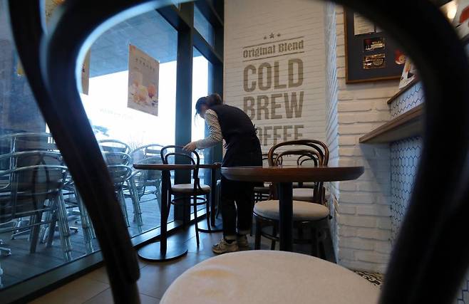 [서울=뉴시스]이영환 기자 = 17일 서울 시내의 한 카페에서 직원이 테이블과 의자를 정리하고 있다. 중앙재난안전대책본부(중대본)에 따르면 오는 18일부터 전국 카페에서 오전 5시부터 오후 9시까지 매장 내 음식과 음료 취식이 가능하다. 2020.01.17. 20hwan@newsis.com