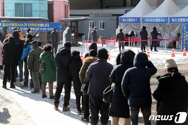 (수원=뉴스1) 조태형 기자 = 7일 오후 경기도 수원역 광장 마련된 임시선별검사소에서 신종 코로나바이러스 감염증(코로나19) 검사를 받기 위한 시민들이 밤사이 내린 눈 위로 줄 서 있다. 2021.1.7/뉴스1