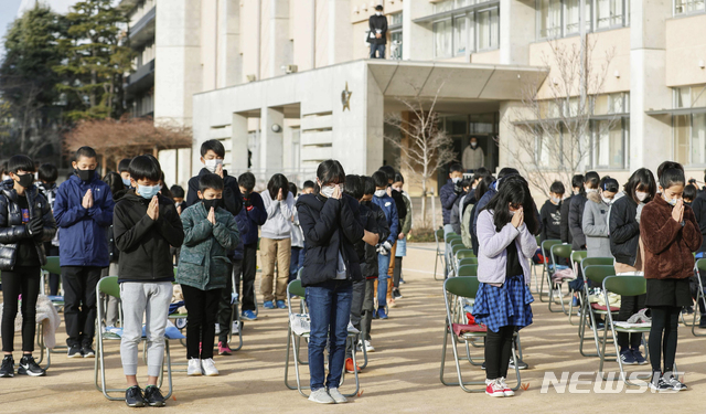 [아시야=AP/뉴시스] 일본 서부 아시야 소재 초등학교에서 17일 열린 1995년 대지진 26주년 추모행사에 참석한 학생들이 코로나19 예방을 위해 마스크를 착용하고 거리를 둔 채 희생자에 묵념과 기도를 드리고 있다. 2021.01.17