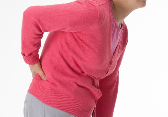 한 중년 여성이 척추관협착증으로 허리 통증을 느끼고 있다/자생한방병원
