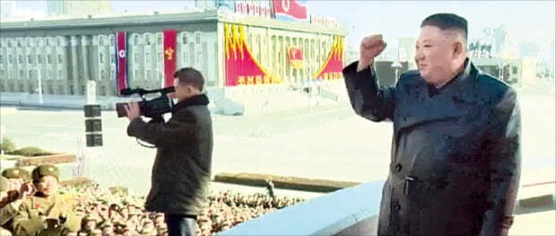 김정은 북한 국무위원장이 지난 16일 노동당 8차 대회를 기념한 열병식 참가자들에게 주먹을 들어 보이며 화답하고 있다. 연합뉴스