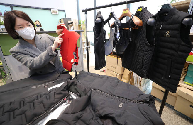 A Korea Consumer Agency official explains heated vests before a press briefing at the government complex in Sejong on Monday. (Yonhap)