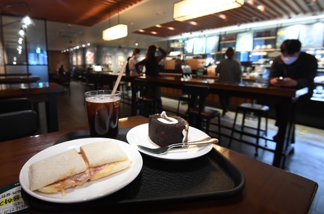 카페, 헬스장, 노래방 등 다중이용시설에 대한 방역조치가 일부 완화된 18일 서울 종로구의 한 커피전문점에서 시민들이 매장 내에서 식음료를 취식하고 있다.