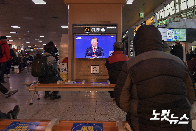 18일 오전 서울역에서 시민들이 문재인 대통령 신년 기자회견을 시청하고 있다. 박종민 기자